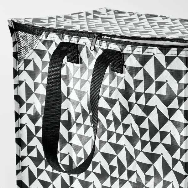 Black and white geometric-patterned reusable shopping bag with sturdy black handles and zipper top, indicating durability and practicality.