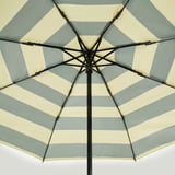Close-up of open KNALLA umbrella. Cream and blue stripes on fabric, sturdy black frame visible from inside.