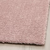 Pastel pink rug close-up, soft texture, thick pile, elegant shine.