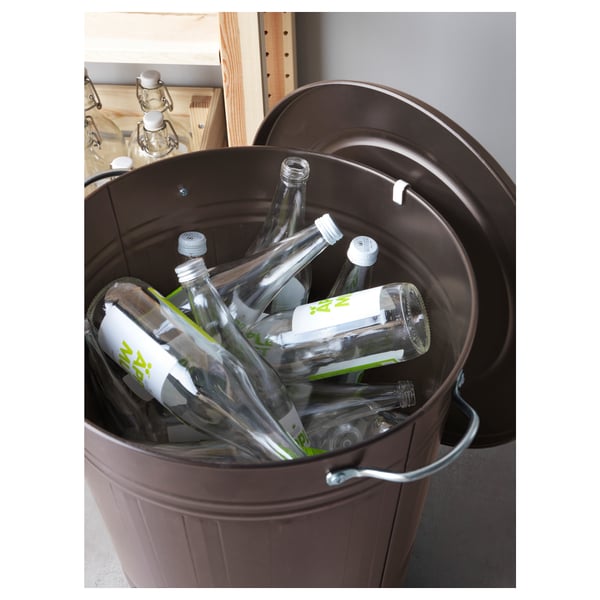 Dark metal bin filled with clear bottles, lid secured on edge. Useful for recycling and easy handling.