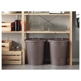 Two gray KNODD bins with lids and handles under a shelf with glass containers and wooden crates.