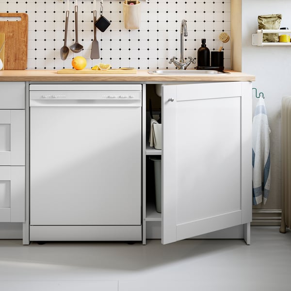 Modern kitchen with white cabinets, wooden countertop, integrated dishwasher, and sink.