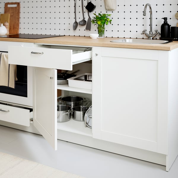 Modern kitchen with open drawer; neat pots and pans; wood worktop; tidy shelter.