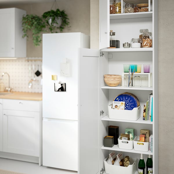 Open kitchen cabinet displays organised items: bowls, cups, jars, and containers, efficiently using wall space for storage.
