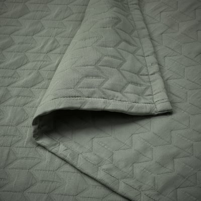 Kolax grey-green recycled polyester quilted bedspread, folded, with geometric pattern.