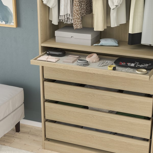 Wooden dresser with pull-out tray holding wallets, belts, and jewelry; soft felt mat and shallow drawers below.