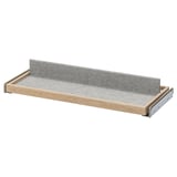 An ikea KOMPLEMENT pull-out tray in beige with grey felt lining. It a sleek design with a metal frame for mounting.