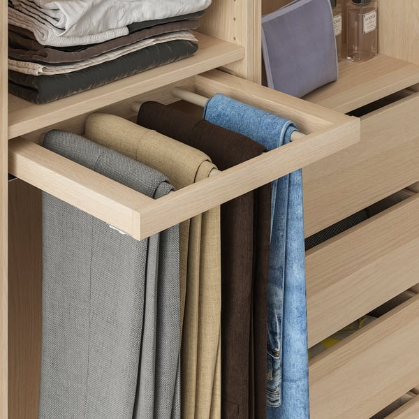 Organized closet with pull-out trousers hanger holding several neatly rolled pants.