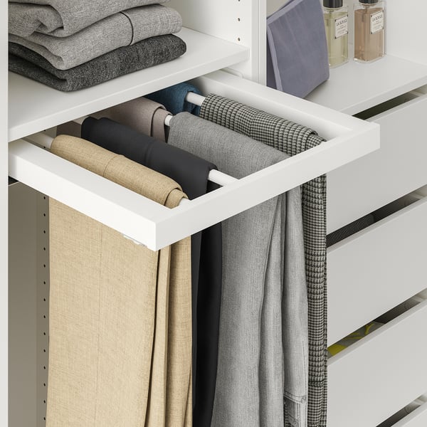 White closet with pull-out trouser hanger holding neatly folded pants.