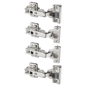 This image displays four KOMPLEMENT hinges in silver color. They are metallic with plastic parts, designed for slow, silent door closure.