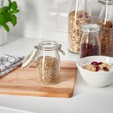 Kitchen counter with sealed jars of grains, dried fruits, seeds, and granola for freshness and organization.