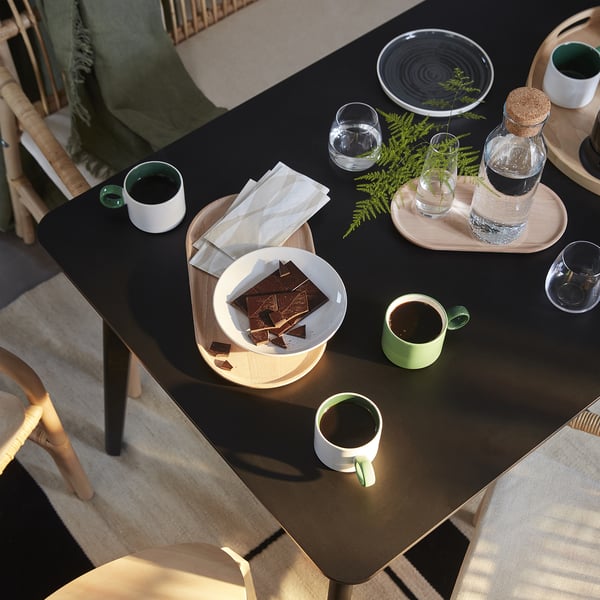 Table setting with chocolate, cups, and blanket.