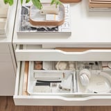 Organized desk drawer with KUGGIS white organizer holding art supplies, small tools, and headphones.