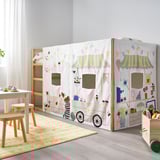 Playful market stall bed curtain for kids, white with colorful illustrations, made of recycled polyester. Fits KURA bed, promotes imaginative play.