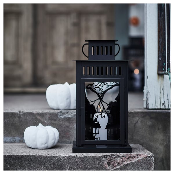KUSTFYR black lantern with spooky cutouts on stone, large white pumpkins.