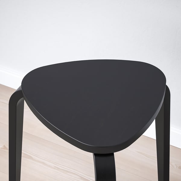 Black stool with layered wood seat, three sturdy bent birch legs, stained & lacquered.