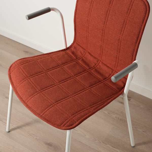 Modern chair with rust-colored, textured fabric and light metal legs. Comfortable and stylish for offices or homes.