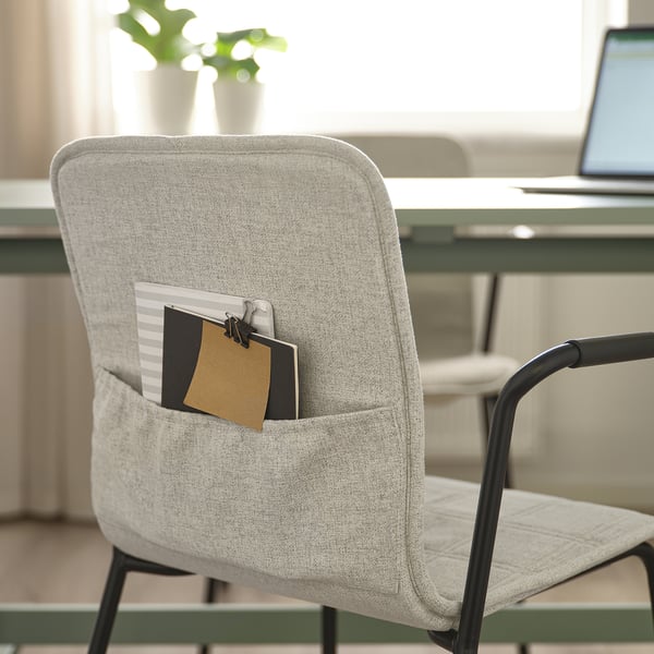 Modern office chair with-notebook pocket, black armrests, near desk with laptop.