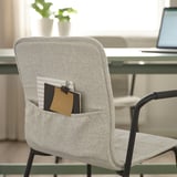 Modern office chair with-notebook pocket, black armrests, near desk with laptop.