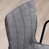 Close-up of upholstered chair back, showcasing quality stitching and dense fabric.