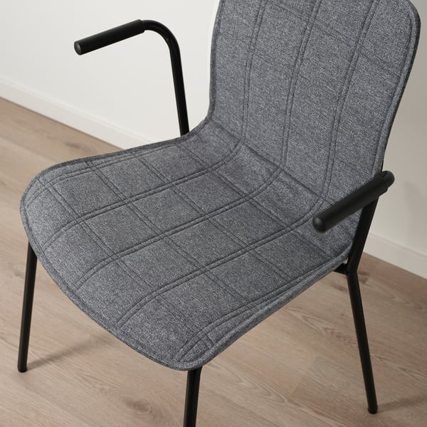 Modern grey office chair with curved back and armrests, on wooden floor.