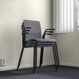 Stacked gray fabric chairs with black metal frames against a wall. Lighting shows gentle shadows, indicating three-dimensional positioning.