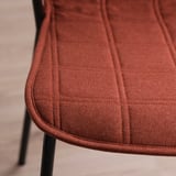 Close-up of a comfortable, textured seat with neat stitching on a modern chair.