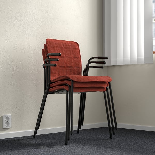 Stacked red LÄKTARE chairs with black metal frames leaning against wall, shown with lumbar support and removable covers.