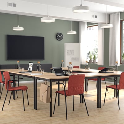 Modern office with LÄKTARE orange conference chairs. Large screens, wooden tables, and red chairs, emphasizing clean design and functionality.