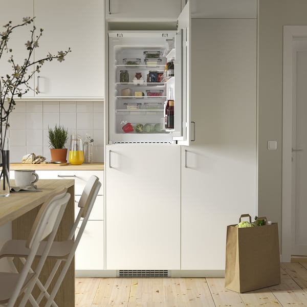 An open modern fridge in a kitchen, showing adjustable glass shelves and led lighting, highlighting its organized and transparent storage.