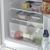 Open refrigerator with fresh produce and adjustable shelves.