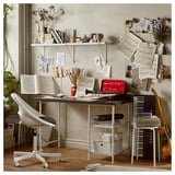 Creative workspace with desk, white chair, musical notes, books, plants, and shelves filled with decor and supplies, all organized neatly.
