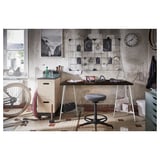 Workroom with bike: desk with chair, storage, tools, decor, and clock.