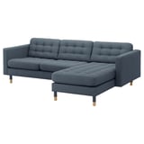Blue modern sofa, tufted back and seat, attached chaise, wooden legs.