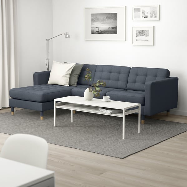 Modern living room with grey sofa, coffee table, and pillows.