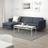 Modern living room with grey sofa, coffee table, and pillows.