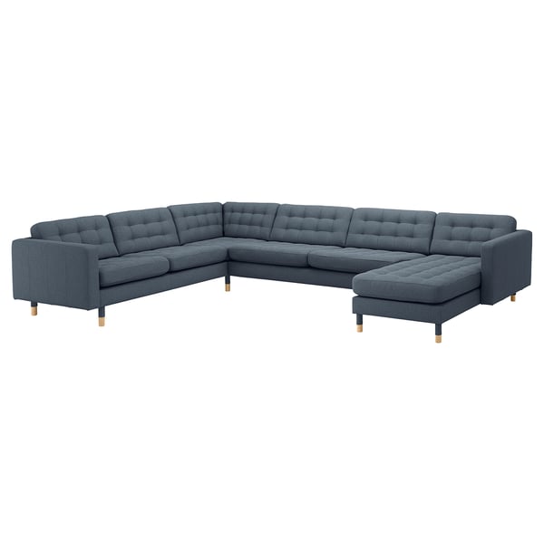 A blue, modern l-shaped sectional sofa with wooden legs, tufted seat and back cushions, and a chaise lounge.