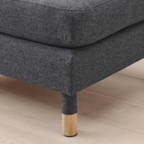 Dark grey upholstered footstool with wooden legs, showing quality fabric and sturdy construction.