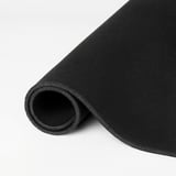 Black gaming mouse pad, partially rolled, on white background.