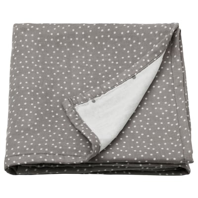 A folded grey muslin swaddle blanket with small white polka dots. Its soft, rectangular, and made from 100% cotton.