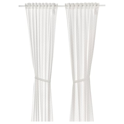 White polka-dot curtains with tiebacks, made of cotton.