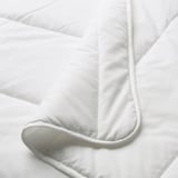 Close-up of white duvet, smooth texture, neatly folded, showcasing stitching detail.