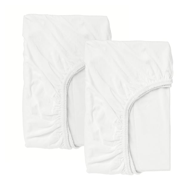 Two crisp white fitted crib sheets, made of cotton, displayed neatly.