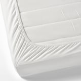 A fitted bed sheet with elastic corners, designed to tightly cover a mattress. Made of soft, breathable cotton ideal for a childs cot.