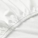Close-up of elastic edge of white cotton sheet, showcasing smooth texture and secure stitching.