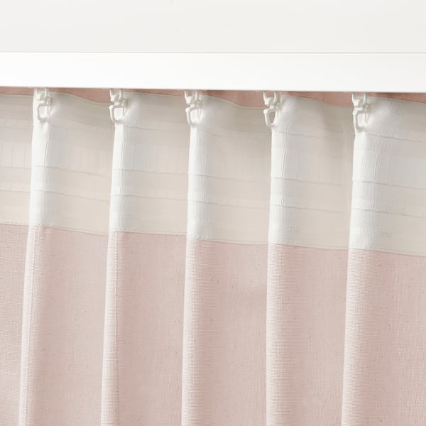 Sheer pink curtains hang with adjustable hooks, letting in diffused light.
