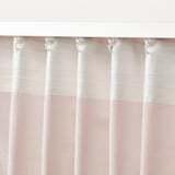 Sheer pink curtains hang with adjustable hooks, letting in diffused light.