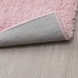 Close-up of pink LINDKNUD rugs soft top and textured grey back, showing its plush and non-slip.