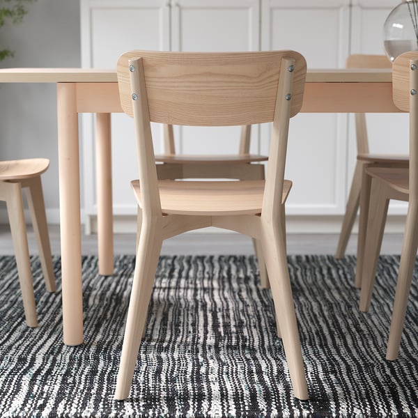 Light wood chairs around a dining table, suitable for various activities. Indoor use only.
