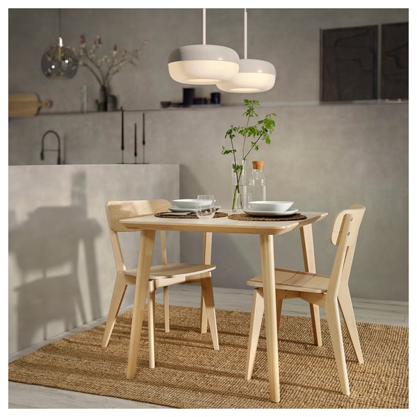 Natural wood dining set with light ash chairs and table, minimalist design, modern lighting above.